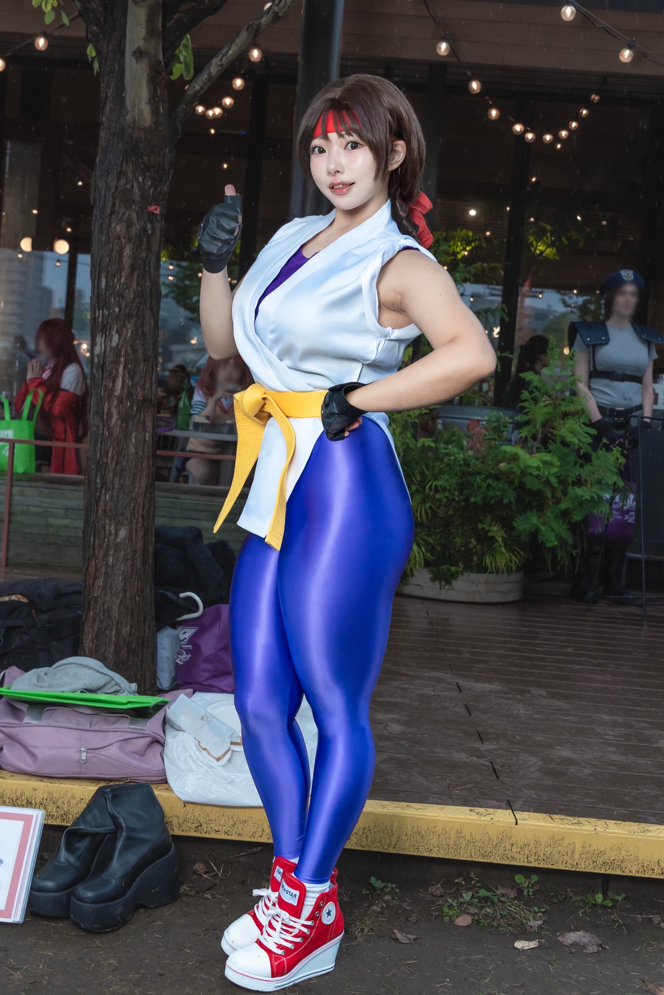 purin cosplay, yuri sakazaki, real life, ryuuko no ken, snk, the king of fighters, cosplay photo, highres, photo (medium), 1girl, black gloves, cosplay, female focus, fingerless gloves, gloves, headband, looking at viewer, martial arts belt, red headband, smile, solo, spandex, teeth, thumbs up, yuri sakazaki (cosplay)