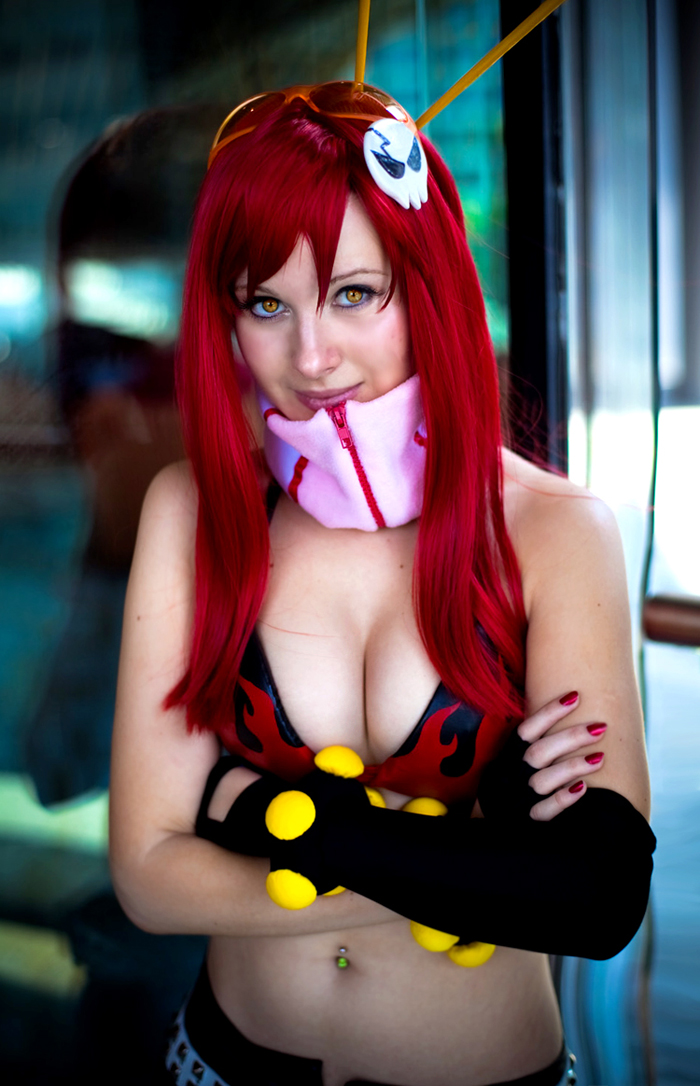 mortelle, yoko littner, tengen toppa gurren lagann, cosplay photo, photo (medium), 1girl, belt, bikini, bikini top only, breasts, cleavage, cosplay, elbow gloves, female focus, fingerless gloves, gloves, large breasts, navel, navel piercing, piercing, red hair, smile, solo, studded belt, swimsuit, yellow eyes