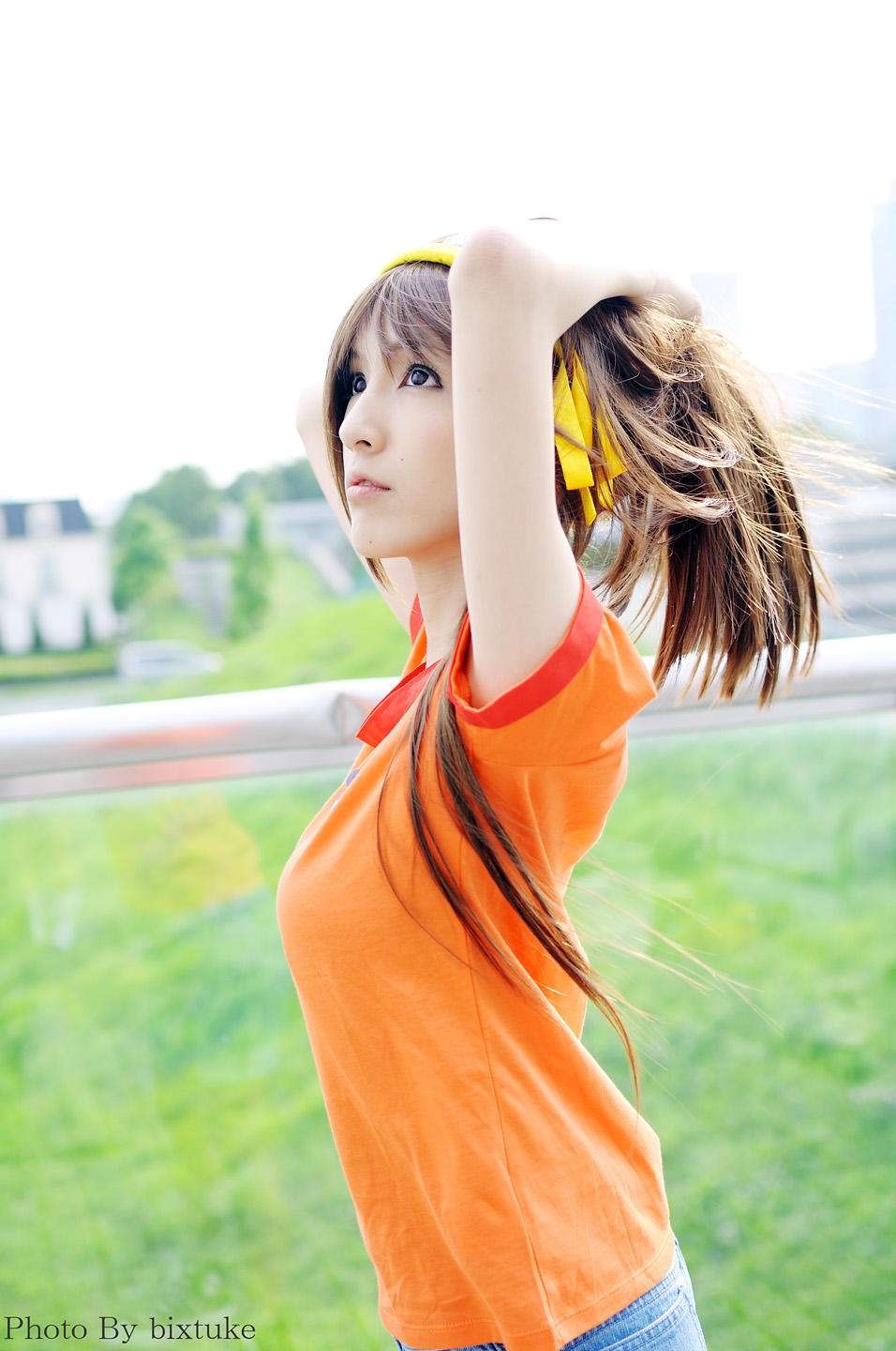 suzumiya haruhi, suzumiya haruhi (young), suzumiya haruhi no yuuutsu, cosplay photo, highres, photo (medium), 1girl, aged down, cosplay, day, female focus, hairband, orange shirt, outdoors, ponytail, shirt, solo