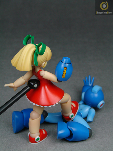 dimension diver, mega man (character), roll (mega man), capcom, mega man (classic), mega man (series), trampling, lowres, photo (medium), 1boy, 1girl, amputee, doll joints, dress, femdom, figure, figure (medium), hair ribbon, joints, ponytail, red skirt, ribbon, skirt, stomping, watermark