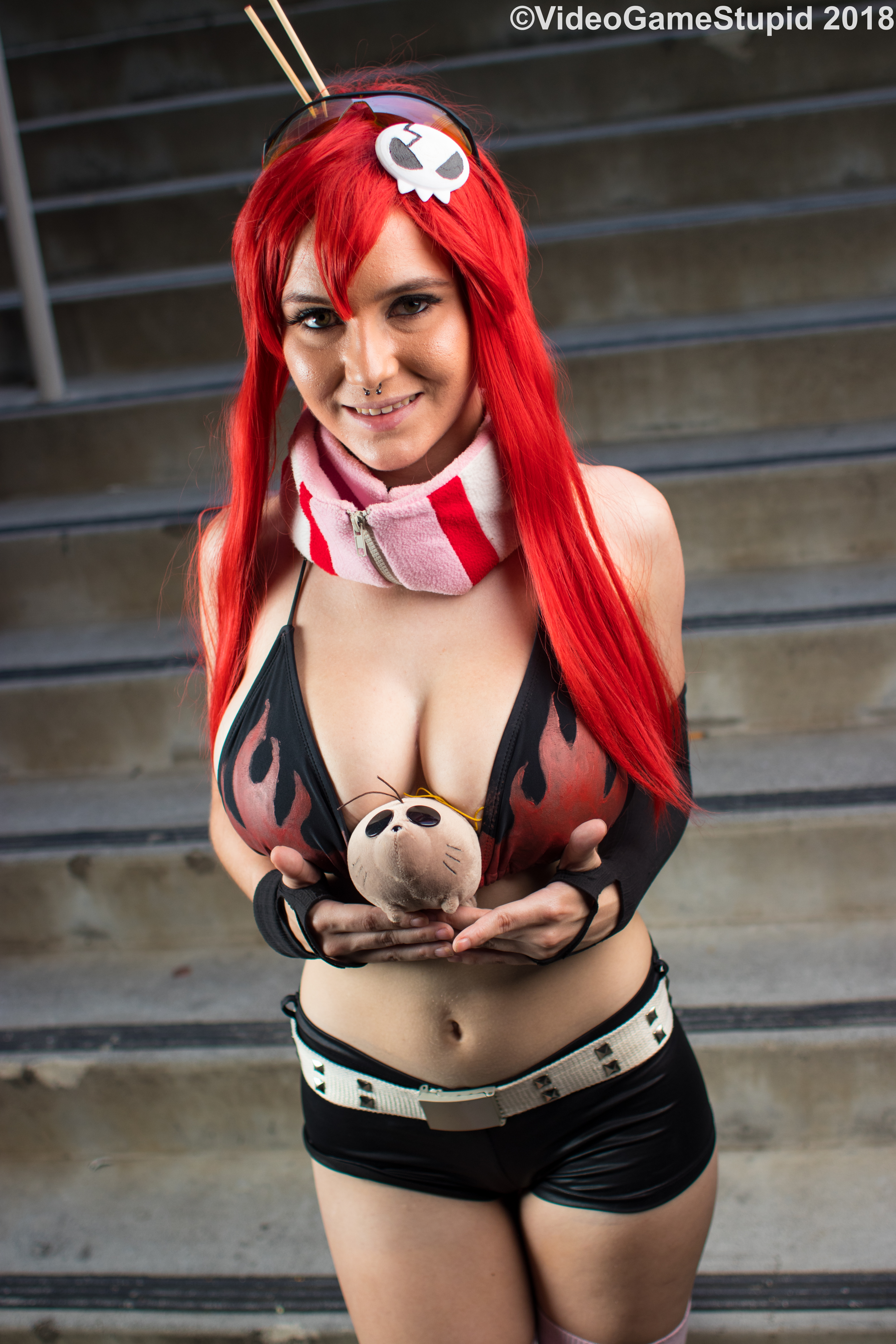 beccadex, boota (ttgl), yoko littner, real life, tengen toppa gurren lagann, cosplay photo, photo (medium), 1girl, asymmetrical gloves, belt, bikini, bikini top only, breasts, cleavage, elbow gloves, fingerless gloves, flame print, gloves, hair ornament, hair stick, high ponytail, large breasts, leather shorts, long sidelocks, looking at viewer, navel, no shirt, nose piercing, nose ring, piercing, pink scarf, ponytail, red hair, scarf, short shorts, shorts, sidelocks, single elbow glove, skull hair ornament, solo, stairs, stairwell, studded belt, sunglasses, uneven gloves, yoko littner (cosplay)