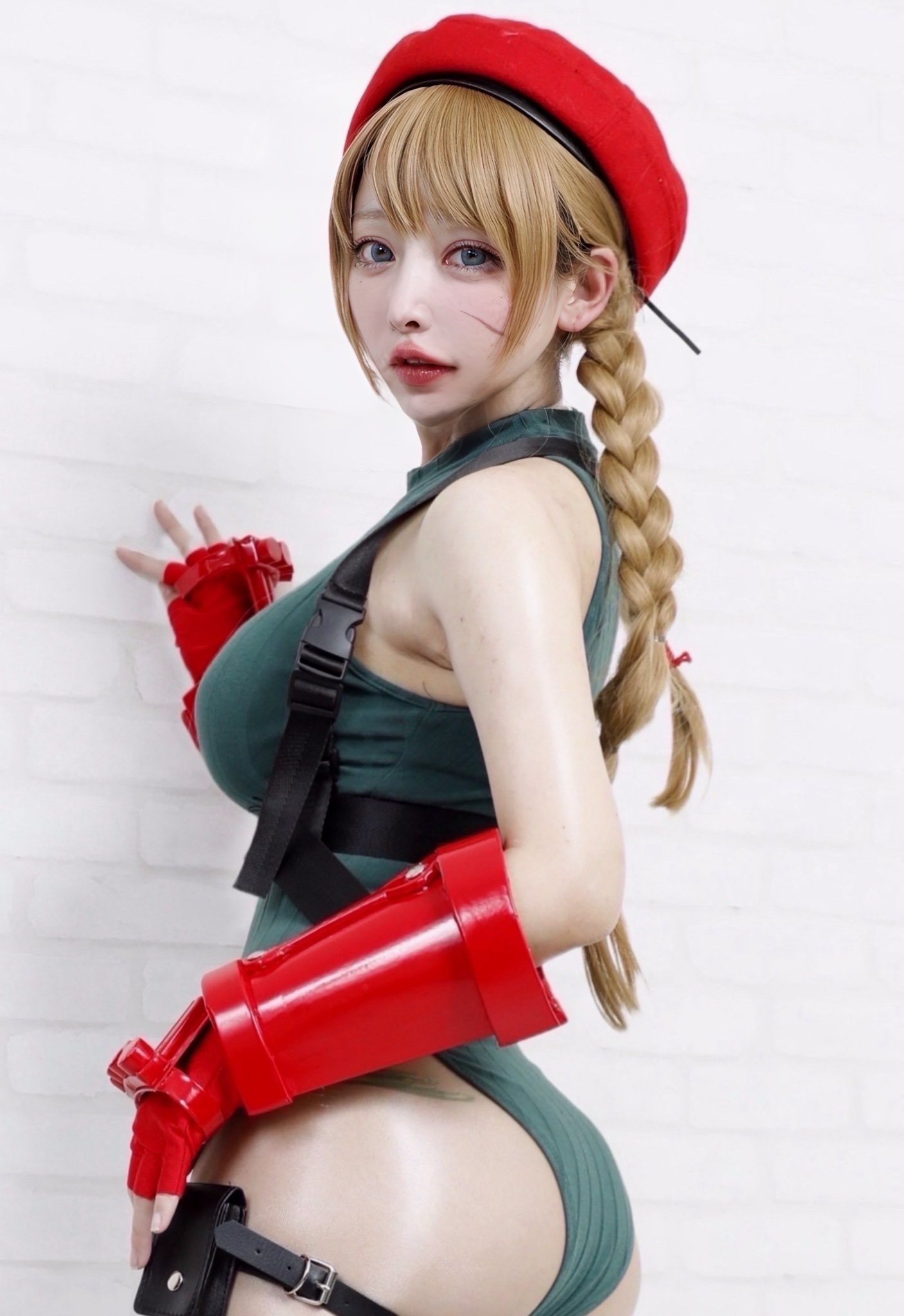 kagamisou, cammy white, capcom, real life, street fighter, cosplay photo, photo (medium), 1girl, ass, bare shoulders, beret, blonde hair, cammy white (cosplay), female focus, fingerless gauntlets, fingerless gloves, gloves, green leotard, hat, highleg, highleg leotard, leotard, looking at viewer, looking back, red gauntlets, red gloves, red hat, scar, scar on face, solo, thigh strap
