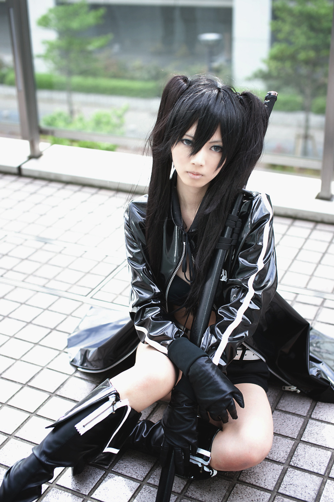 black rock shooter (character), sera (real life), black rock shooter, cosplay photo, photo (medium), 1girl, belt, bikini, bikini top only, black hair, black rock shooter (cosplay), black theme, braid, cosplay, female focus, hood, hooded jacket, jacket, katana, long hair, short shorts, shorts, solo, swimsuit, sword, twin braids, weapon