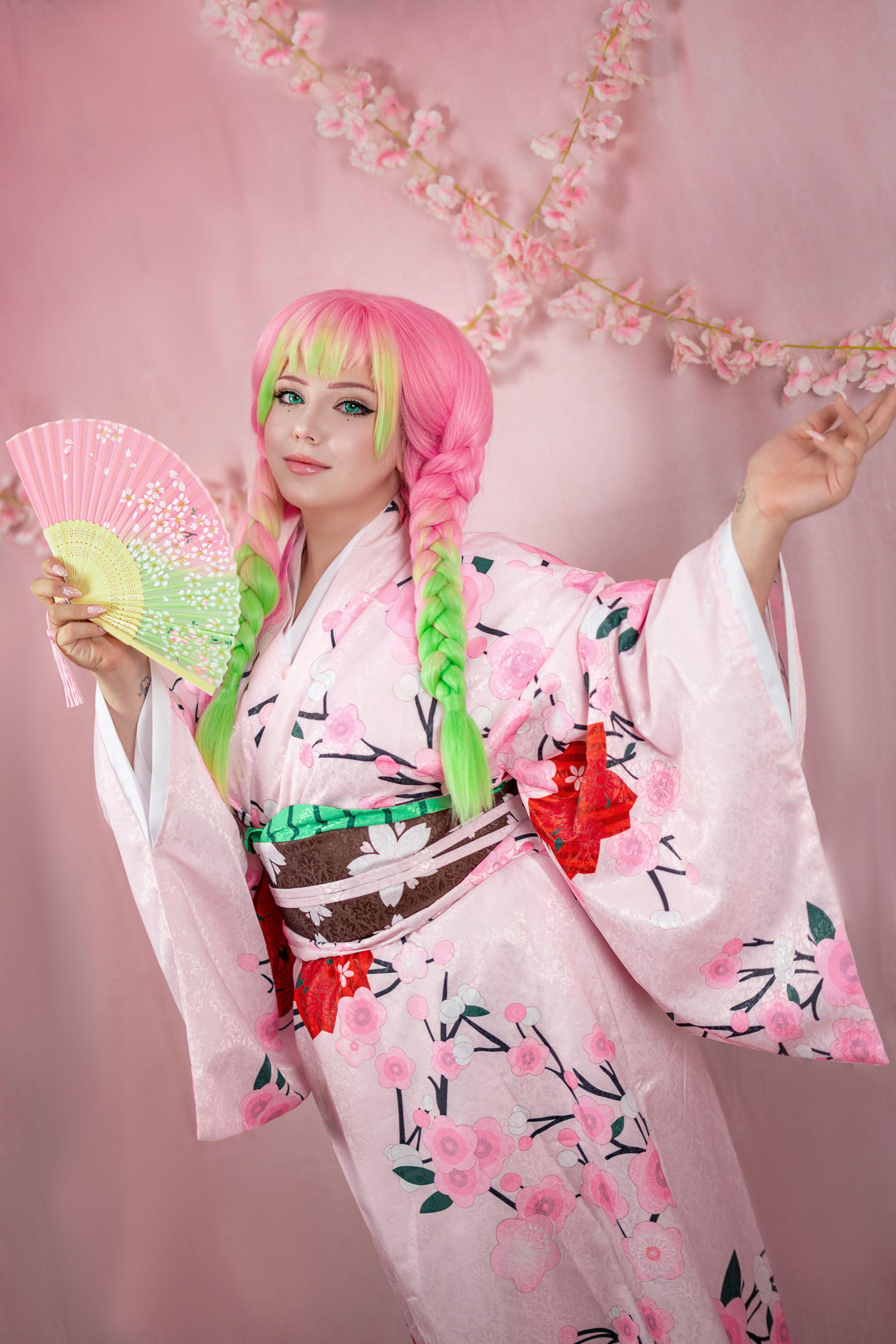 kanroji mitsuri, kimetsu no yaiba, real life, absurdres, highres, 1girl, braid, cosplay, female focus, folding fan, gothlanie, green eyes, green hair, hand fan, holding, holding fan, japanese clothes, kanroji mitsuri (cosplay), kimono, long hair, matching hair/eyes, mole, mole under each eye, mole under eye, multicolored hair, multiple moles, pink hair, solo, twin braids, two-tone hair