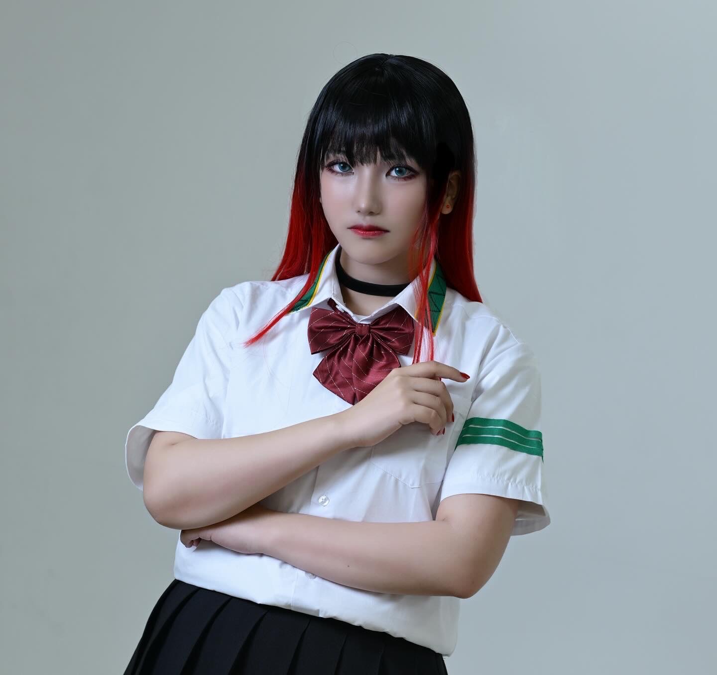 rrrrr0396, tsubakino tasuku, real life, wind breaker (nii satoru), commentary, cosplay photo, highres, photo (medium), 1boy, androgynous, armband, bare legs, black hair, black skirt, blue eyes, bow, closed mouth, collared shirt, contrapposto, cosplay, crossed arms, indoors, jacket, japanese (nationality), male focus, multicolored hair, pleated skirt, red bow, red hair, red lips, red nails, shirt, sidelocks, simple background, skirt, solo, straight hair, streaked hair, tsubakino tasuku (cosplay), unworn jacket, white background, white shirt