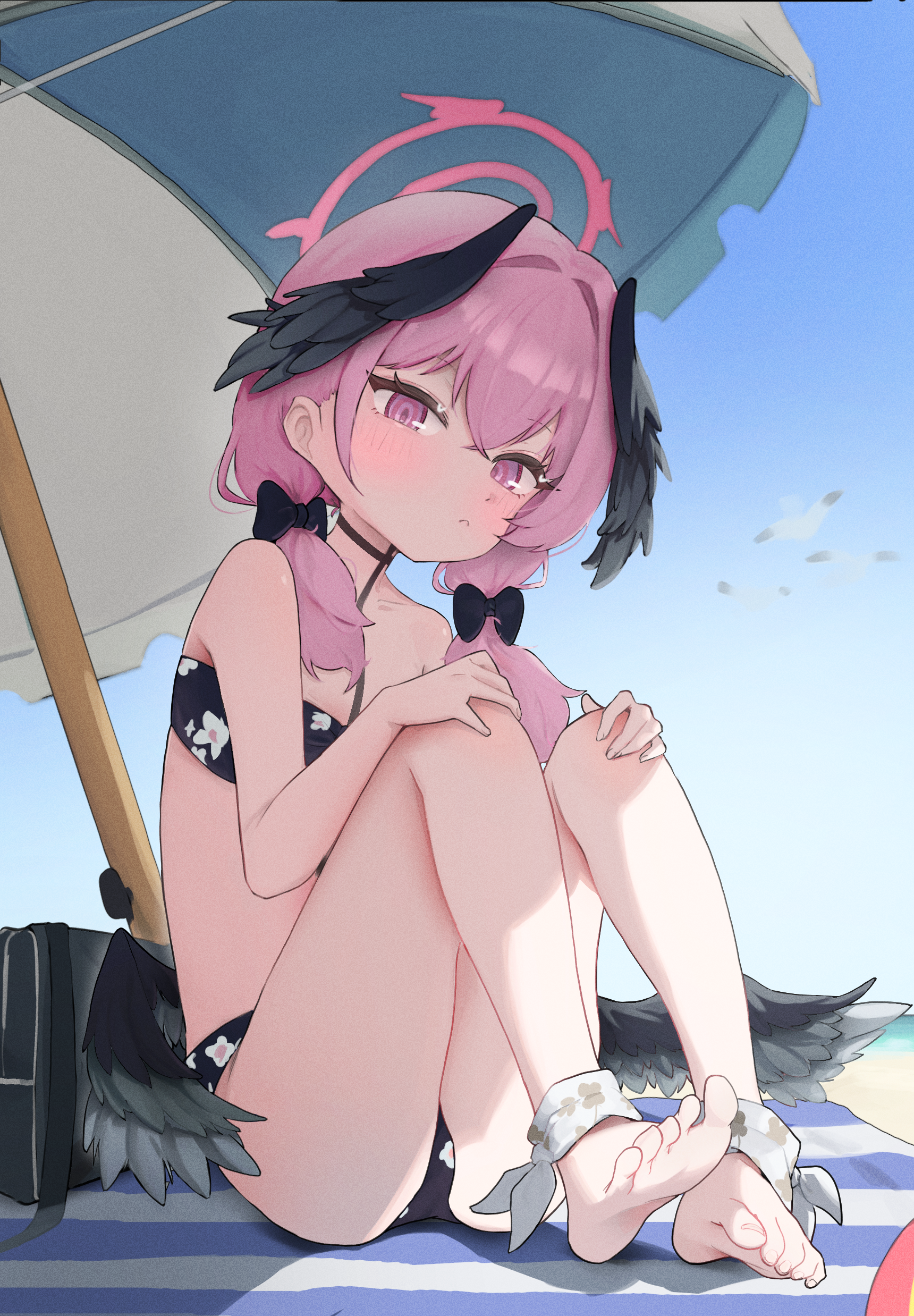 seulraimbbang, koharu (blue archive), koharu (swimsuit) (blue archive), blue archive, absurdres, commentary, highres, korean commentary, 1girl, ankle ribbon, bag, barefoot, beach, beach mat, beach umbrella, bikini, black bikini, black wings, blue sky, blush, body markings, day, duffel bag, feathered wings, feet, floral print, floral print bikini, halo, hands on own knees, head wings, knees up, leg ribbon, looking at viewer, low twintails, low wings, official alternate costume, outdoors, pink eyes, pink hair, pink halo, print bikini, ribbon, simple bird, sitting, sky, soles, solo, swimsuit, toes, twintails, umbrella, wings