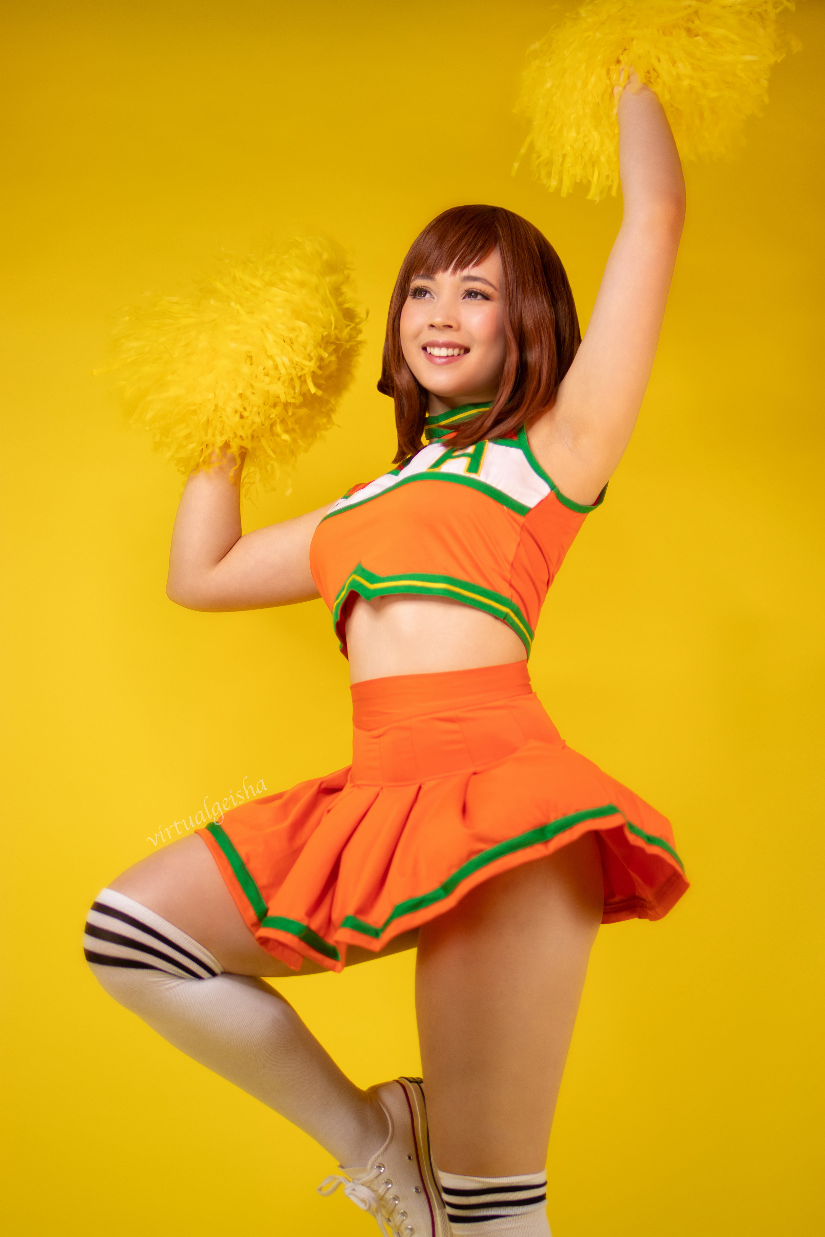 virtualgeisha, uraraka ochako, boku no hero academia, real life, cosplay photo, photo (medium), 1girl, armpits, breasts, brown eyes, brown hair, cheerleader, contrapposto, female focus, grin, lips, matching hair/eyes, orange shirt, orange skirt, pom pom (cheerleading), shirt, shoes, short hair, sidelocks, skirt, smile, sneakers, socks, solo, teeth, thighs, u.a. cheerleader uniform, uraraka ochako (cosplay), white socks, yellow background